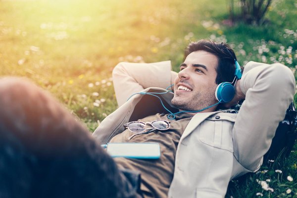 A man lying down and listening to music